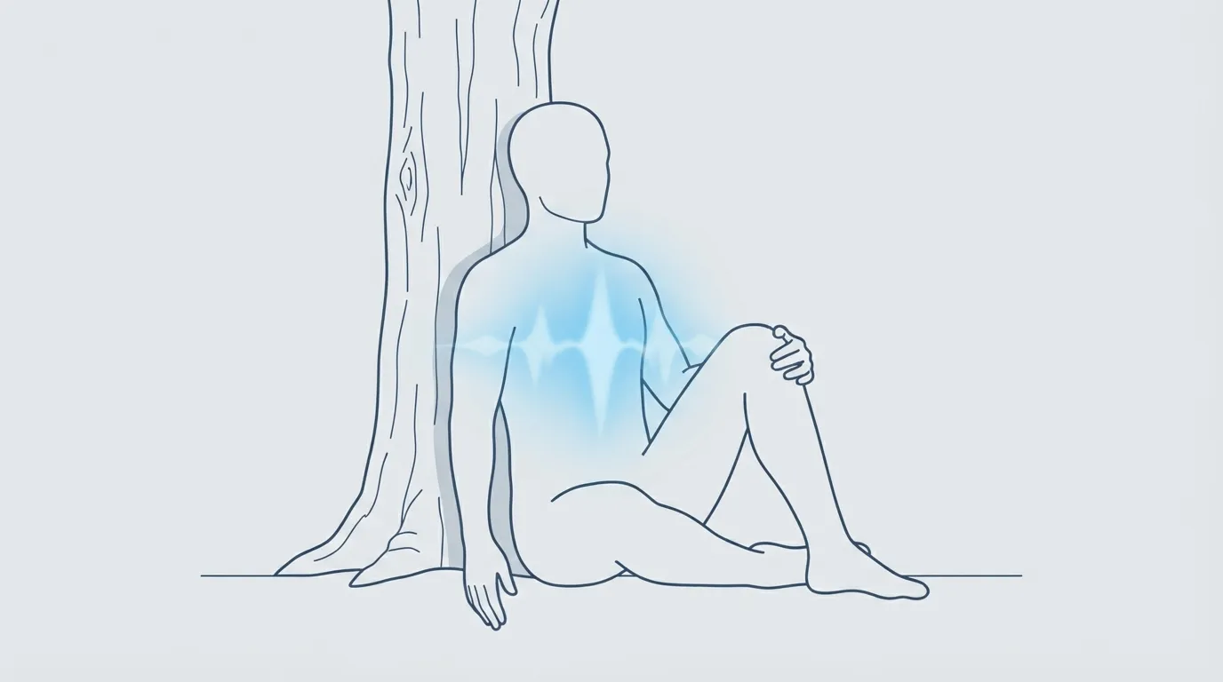 Une personne assise dos contre un arbre, bras affecté relâché, mains posées sur un genou remonté, position de détente